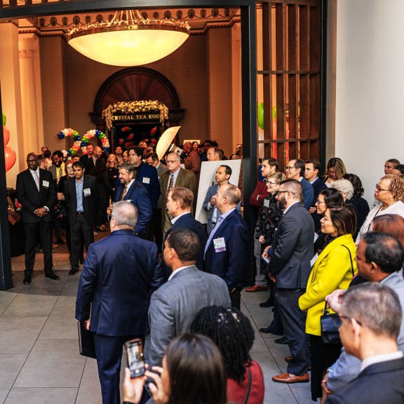 crowd of attendees at an event listening to a speaker standing up