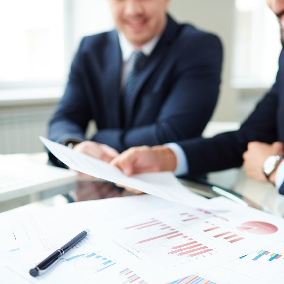 Two men looking at papers on the table