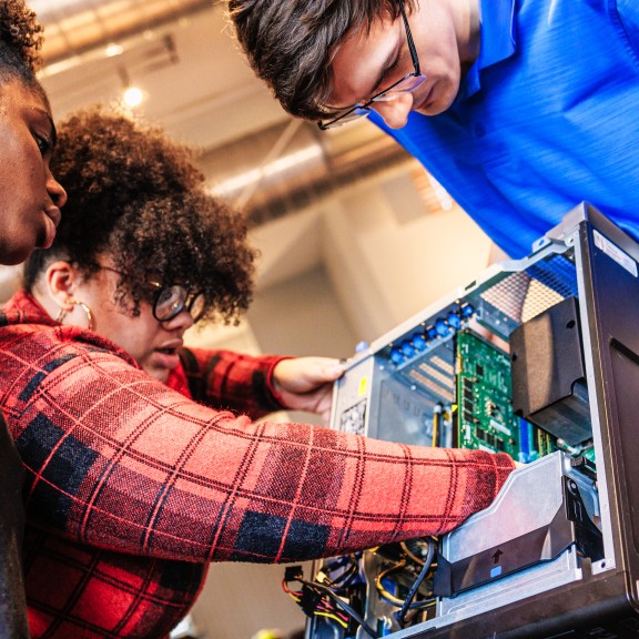 Group Taking A Part a Computer Tower