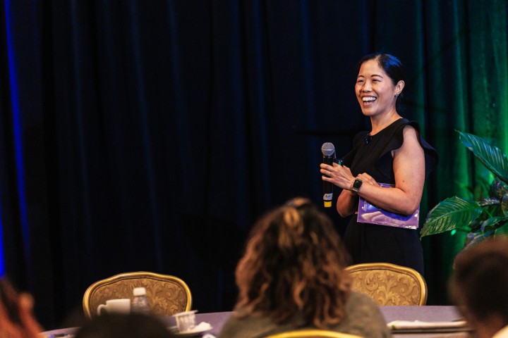 Women speaker on stage holding microphone