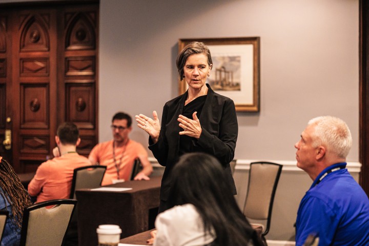 Woman speaking to adult learners at tables