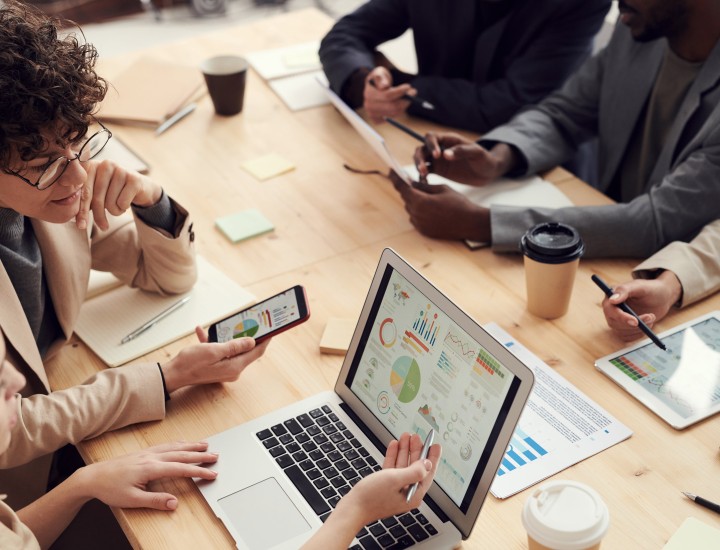 People gathered around a table looking at a laptop