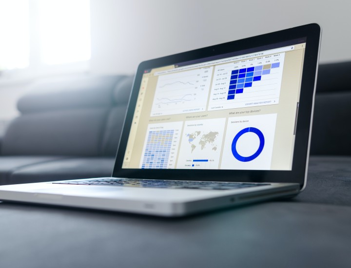 Laptop screen with multiple automation graphics for digital analysis. Laptop sitting on grey seats.