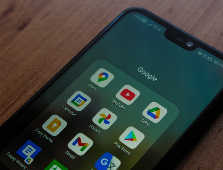 Google apps in a folder on a black smart phone.