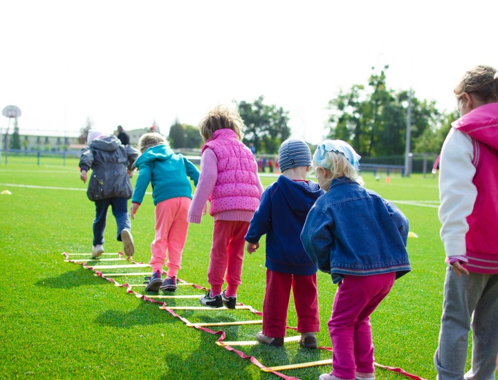 Children playing a ladder game outside on a sunny day